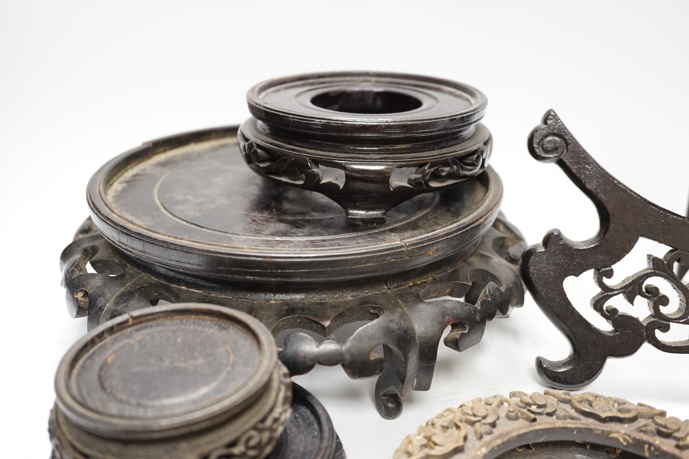 Assorted Chinese wooden and metal stands, largest 25cm in diameter